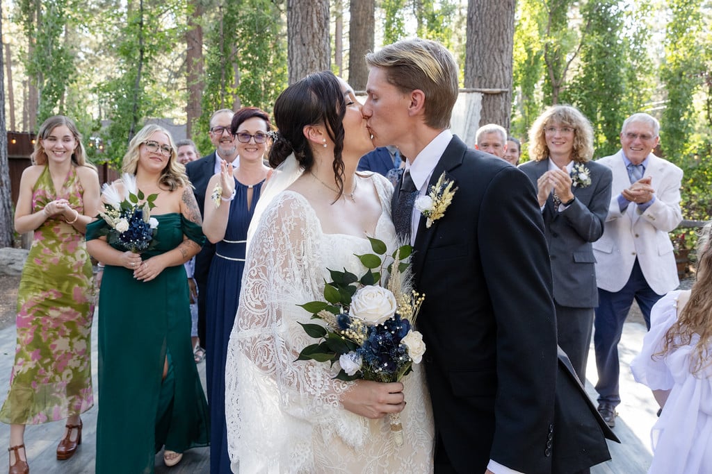 Newlyweds kissing in Lake Tahoe surrounded by cheering friends and family