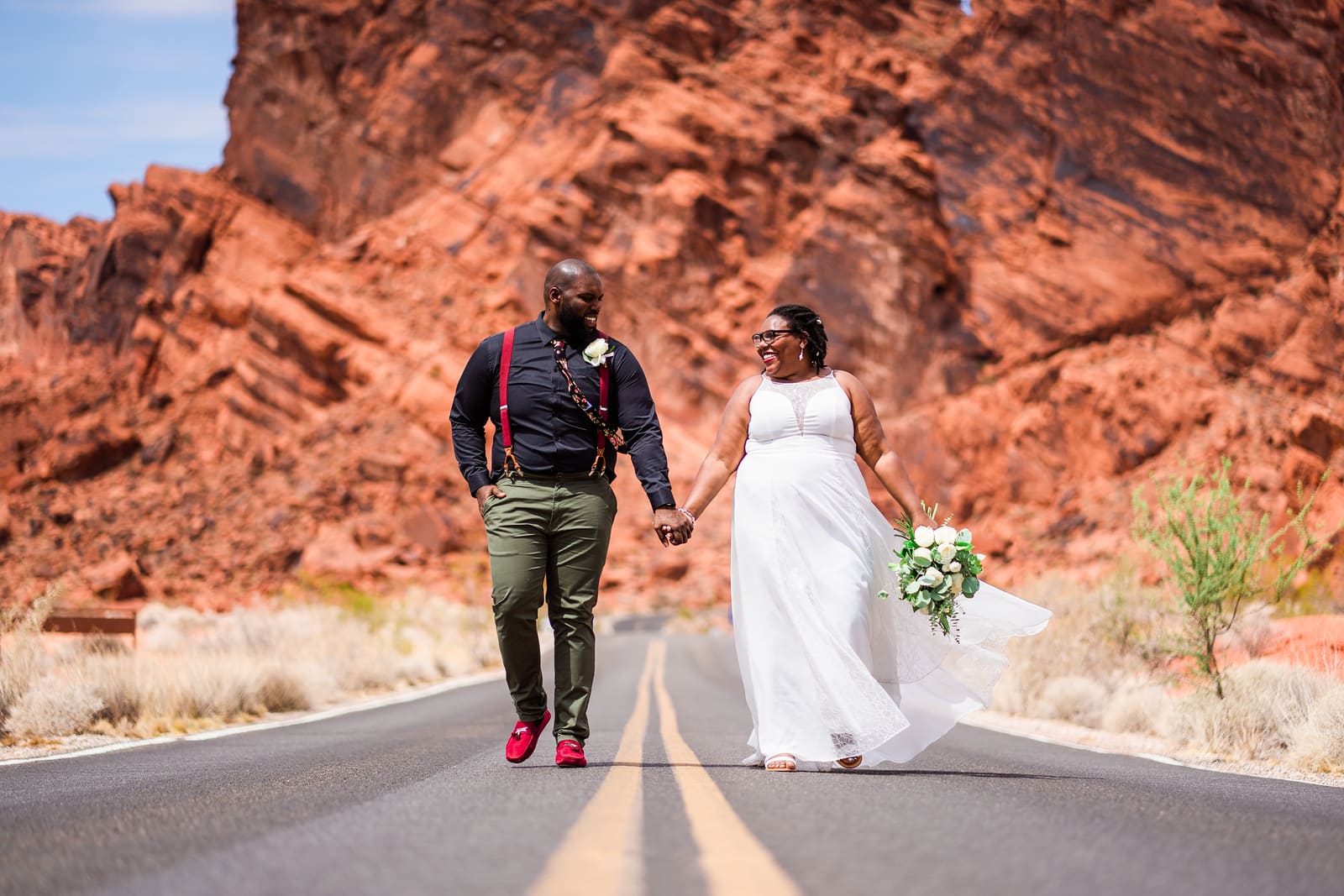 Newlyweds holding hands and walking at Valley of Fire State Park